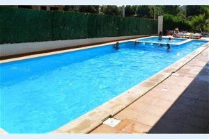 una grande piscina blu con gente dentro di Casa Azul, Fast WI-FI, Airco, Pool & BBQ near The Beach Praia da Rocha a Portimão