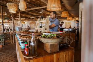 un hombre preparando comida en un buffet en un restaurante en Océan Vagabond Lassarga, en Dakhla