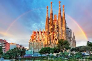 a rainbow in front of a large cathedral at Lux Apartments Barcelona in Barcelona