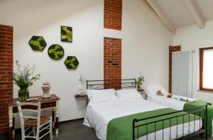 a bedroom with two beds and a table with a chair at Ca' Nadin Agriturismo in San Damiano dʼAsti