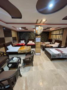 una habitación de hotel con varias camas, mesas y sillas en POLO LAND HOTEL Skardu en Tandal