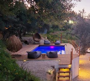 una piscina en un patio con terraza de madera en luxury dome tents ikaria ap'esso2, en Raches