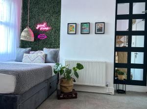 a bedroom with a bed and a potted plant at J&W Apartments with free parking in Liverpool