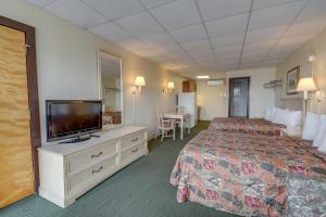 a hotel room with a bed and a flat screen tv at Surf Inn Suites in Ocean City