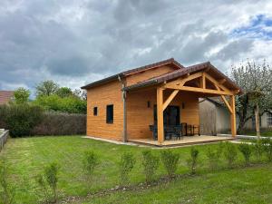 a log cabin with a deck in a yard at Les Chalets près de Chalain in Montigny-sur-lʼAin