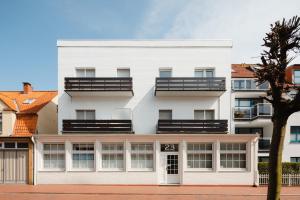 ein Apartmenthaus mit weißer Fassade in der Unterkunft Kapkieker in Norderney