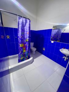 a blue bathroom with a shower and a toilet at El Palmar in Guaduas
