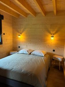 a bedroom with a bed in a wooden cabin at Les Chalets près de Chalain in Montigny-sur-lʼAin +39 photos