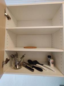 un armario de cocina blanco con utensilios. en Lille hyggelig centrum lejlighed! No17, en Billund