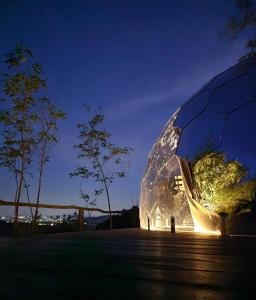 a person standing in front of a glass dome at night at Camping Paradiso in Pesaro