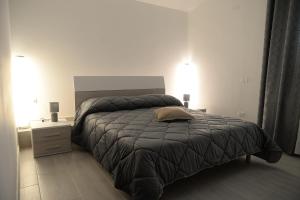 een slaapkamer met een groot bed en een nachtkastje bij RESIDENCE CIMINO emozioni mediterranee in Scanzano