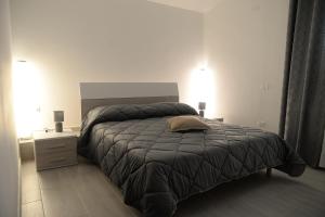 a bedroom with a large bed and a night stand at RESIDENCE CIMINO emozioni mediterranee in Scanzano