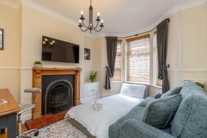 een woonkamer met een blauwe bank en een open haard bij Three Bedroom Apartment - Contractors & Groups welcome in Northampton by Centro Stays - Free WiFi & Parking in Northampton