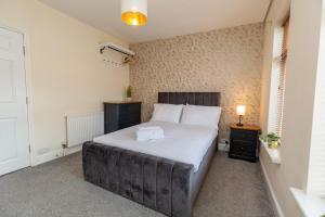 een slaapkamer met een groot bed en 2 nachtkastjes bij Three Bedroom Apartment - Contractors & Groups welcome in Northampton by Centro Stays - Free WiFi & Parking in Northampton