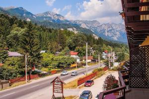 uma cidade com carros a descer uma rua com montanhas em Hotel Riviera em Sinaia