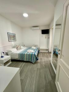 ein Schlafzimmer mit einem Bett und einem TV in der Unterkunft La Marina B&B in Civitavecchia