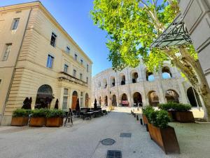 a courtyard in a building with tables and benches at Nî'douillet-P3 Terrasse et climatisé-coeur de ville in Nîmes