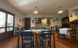 un comedor con mesas de madera y sillas azules en Residenza di Campagna Dolmen Motorra en Dorgali