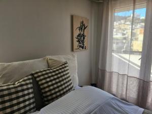a bedroom with a bed with pillows and a window at Rooftops in Kavala