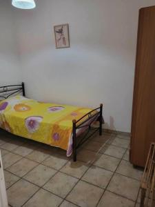 une chambre avec un lit avec une couverture jaune dans l'établissement Filomila apartment Agia Foteini, à Chios