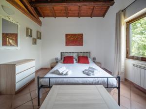 Un dormitorio con una cama con almohadas rojas. en il lago, en Bracciano