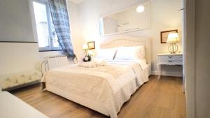 a white bedroom with a bed and a chair at CINQUE TERRE MONEGLIA in Moneglia