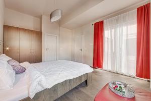 a bedroom with a large bed and a red window at ARI Central Grand Apartments - Luxurious Stay in Arad +227 photos