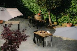 a patio with tables and chairs and an umbrella at Ca' Nadin Agriturismo in San Damiano dʼAsti
