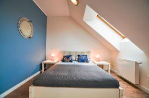 una camera da letto con un letto con pareti blu e una scala di CITYSTAY Powstancow Warszawskich Gdansk Apartment a Danzica