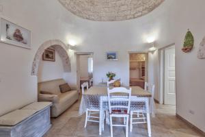 ein Wohnzimmer mit einem Tisch und einem Sofa in der Unterkunft Trulli Elios in Cisternino