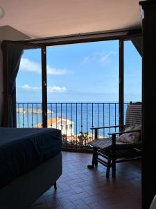 1 dormitorio con vistas al océano desde el balcón en B&B Chianalea 54, en Scilla