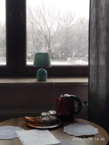 une lampe assise sur une table à côté d'une fenêtre dans l'établissement Hotelik rodzinny 365 pokoje z łazienkami, à Łódź