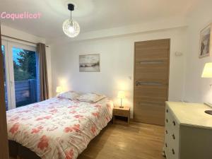 a bedroom with a bed and a dresser and a window at Le Chêne in Névez