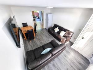 an overhead view of a living room with a leather couch at 3 Bedroom Spacious Modern Comfortable Home in Rochdale, Work, Relax, Explore Manchester, Oldham, Bury in Rochdale