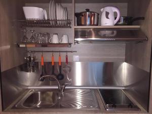 a stainless steel kitchen with a sink and utensils at Frodo Studios in Kavos