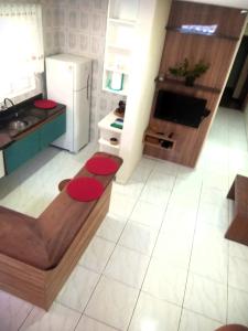 a kitchen with red counters and a white floor at Cantinho Aconchego in Santo Antônio do Pinhal