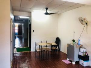 a dining room with a table and chairs and a ceiling fan at NR Guest House in Kangar