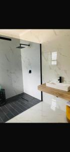 Golfview luxury apartment في خليج ريتشاردز: حمام أبيض مع حوض ومكتب