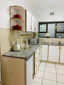 une cuisine avec des placards blancs et un comptoir dans l'établissement Golfview luxury apartment, à Richards Bay