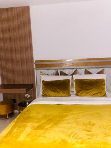 Golfview luxury apartment في خليج ريتشاردز: غرفة نوم بسرير كبير عليها أغطية ومخدات صفراء
