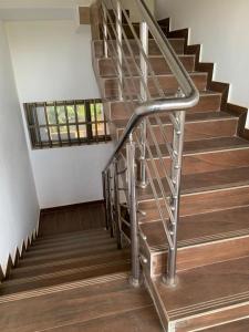 a metal spiral staircase in a house with wooden floors at Adole Guest House in Abomey-Calavi