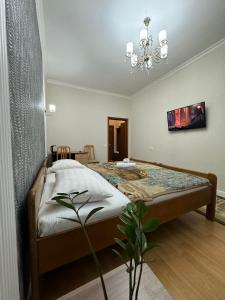 a bedroom with a bed and a chandelier at Mini-Hotel Sultan in Astana