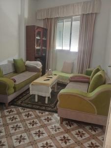 a living room with two couches and a table at Dar manena in Kairouan