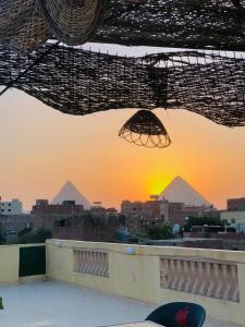 uma vista das pirâmides a partir do telhado de um edifício em four pyramids Guest house em Cairo