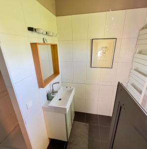 een witte badkamer met een wastafel en een spiegel bij casa-tena-Sorède in Sorède