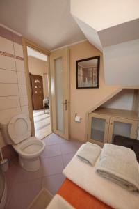 La salle de bains est pourvue de toilettes, d'un lavabo et d'un escalier. dans l'établissement Λειτουργικό σπίτι σε κεντρική τοποθεσία, à Kalymnos