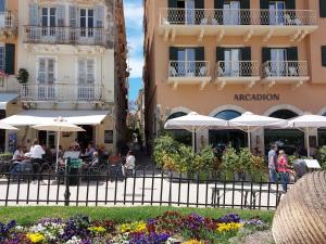 a restaurant in front of a building with tables and umbrellas at La casetta di Emilia in Corfu Town