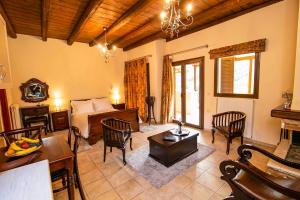 a living room with a bed and a table and chairs at ΕΣΠΕΡΙΔΕΣ in Kalavrita