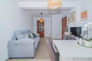 ein Wohnzimmer mit einem Sofa und einem Tisch in der Unterkunft Delfín Retreat con Terraza junto a parada de Metro in Granada