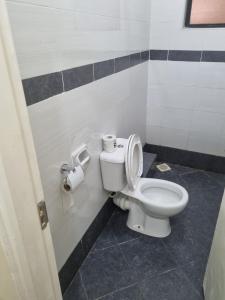 a bathroom with a toilet and two rolls of toilet paper at Alpha homes in Nakuru